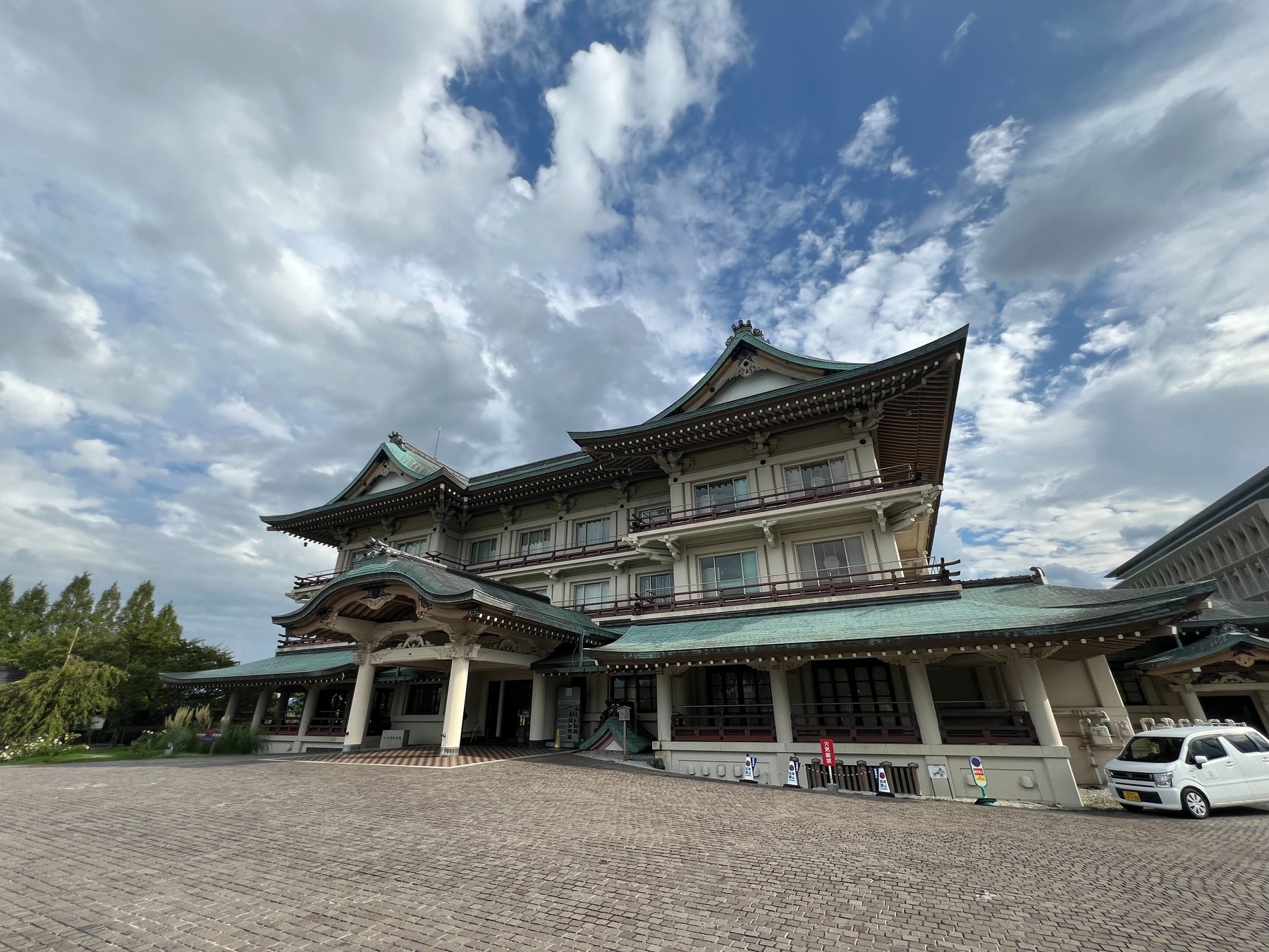 青空と雲の下に立つびわ湖大津館の外観