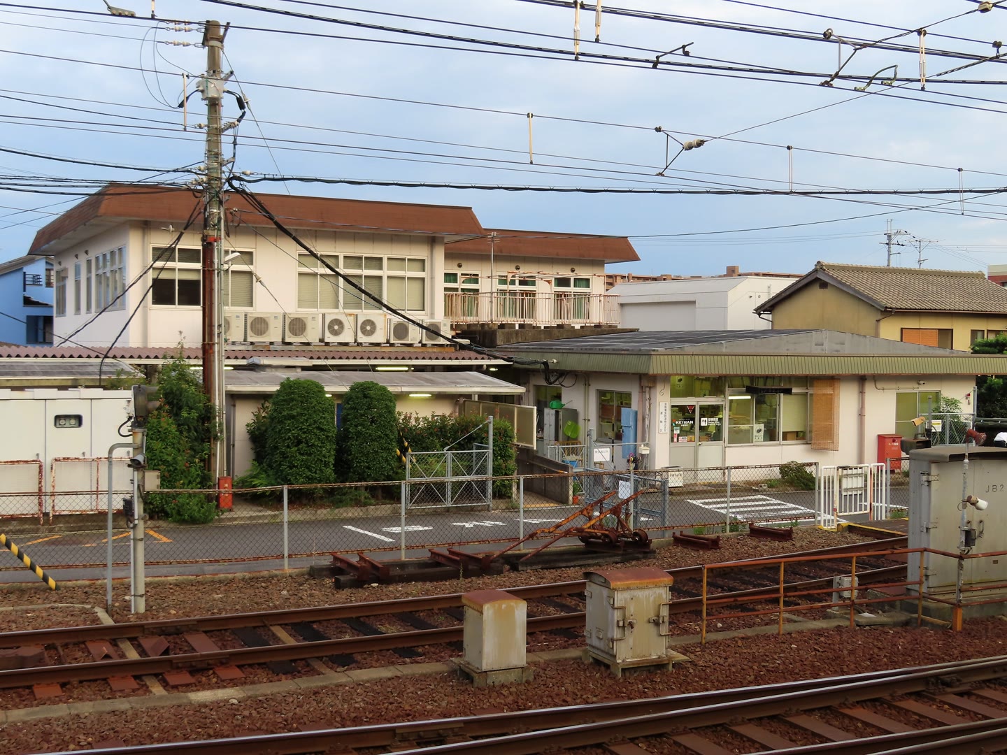 線路越しに見た京阪近江神宮前駅の駅務室と周辺の建物