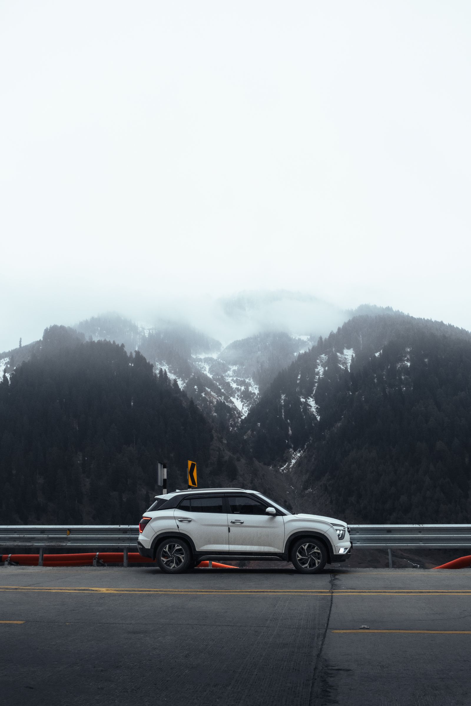 山の見える道を走る車のイメージ