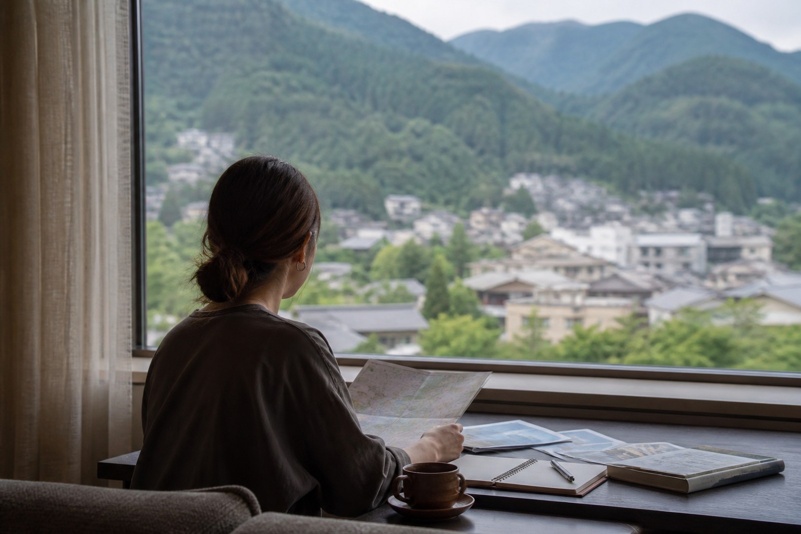 温泉街を眺めながら宿泊プランを確かめる旅行者